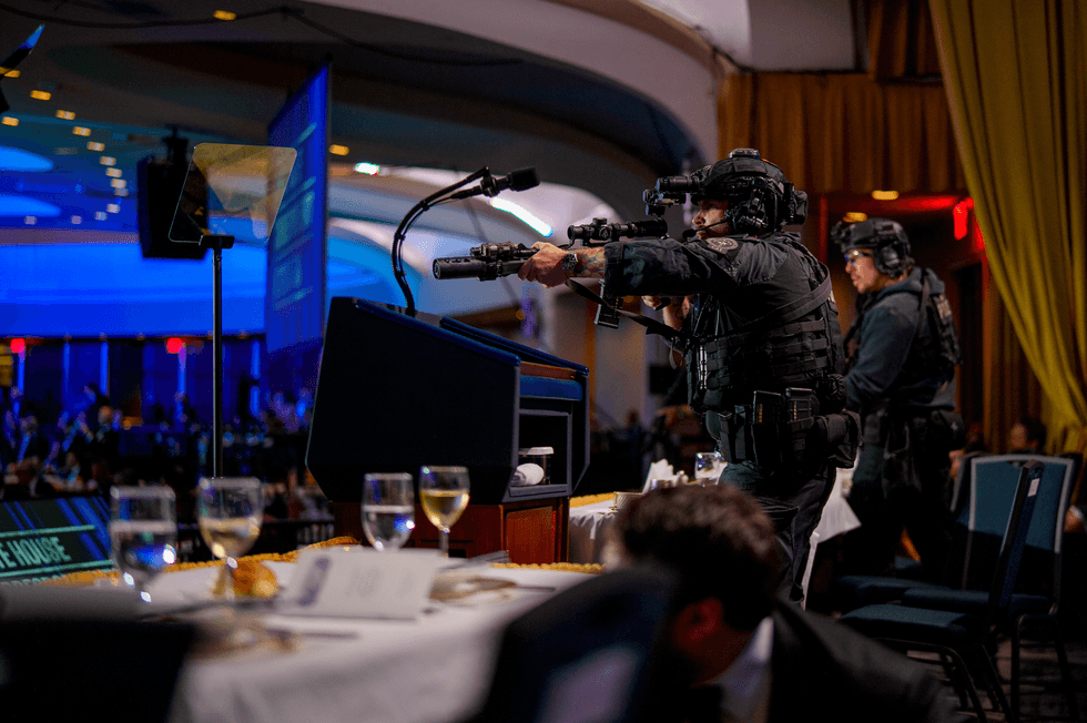 Armed Secret Service agents stand on stage during a shooting incident at the annual White House Correspondents Association Dinner at the Washington Hilton on April 25, 2026 in Washington, DC