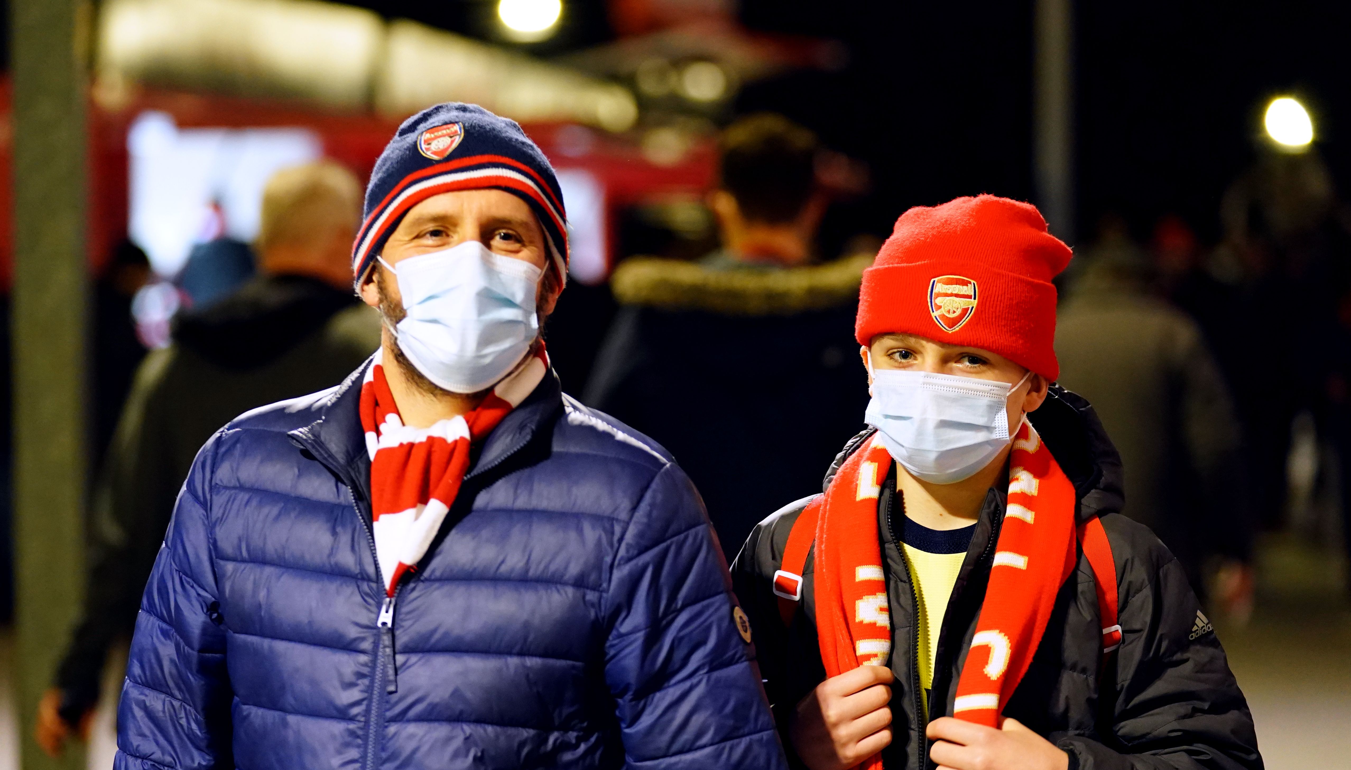 Arsenal fans arrive wearing face masks ahead of the Premier League match at Emirates Stadium.
