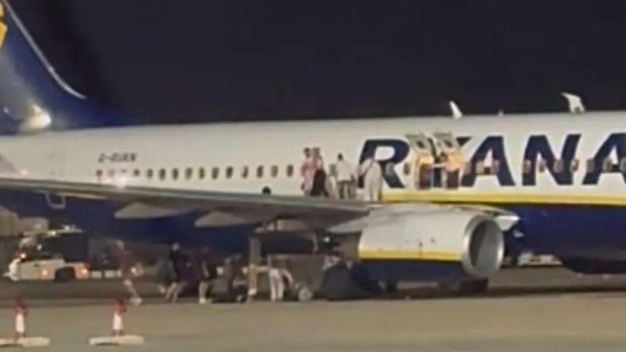 At least 18 people injured after Ryanair plane catches on fire as passengers forced to climb on jet's wings