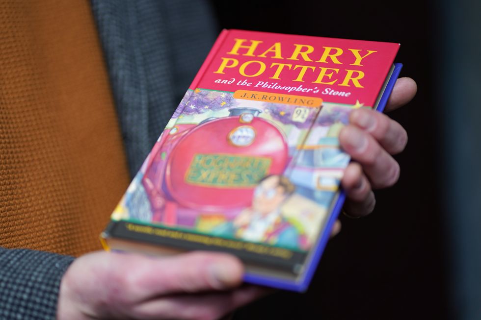 Auctioneer Jim Spencer holds a pristine first edition hardback of JK Rowling's Harry Potter and the Philosopher's Stone, one of only 500 produced in the first print run in 1997, on display at Hansons' Auctioneers at Bishton Hall, Staffordshire. The book has never been read and was kept in darkness for 25 years inside a protective sleeve and could fetch up to 100,000 when it goes under the hammer at Hanson's Library Auction on March 9. Picture date: Monday March 7, 2022.