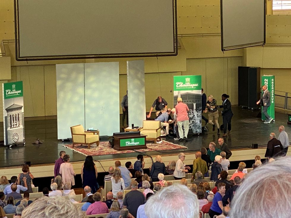 Author Salman Rushdie is helped by people after he was stabbed on stage before his scheduled speech at the Chautauqua Institution, Chautauqua, New York, U.S., August 12, 2022, in this picture obtained from social media.