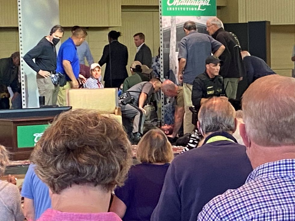 Author Salman Rushdie is treated by emergency personnel after he was stabbed on stage before his scheduled speech at the Chautauqua Institution, Chautauqua, New York, U.S., August 12, 2022, in this picture obtained from social media.