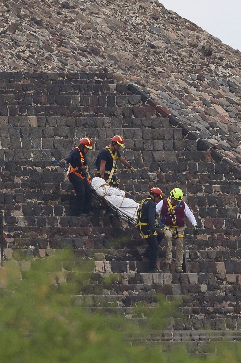 Authorities haul a stretcher down the side of the pyramid after the shooting\u200b