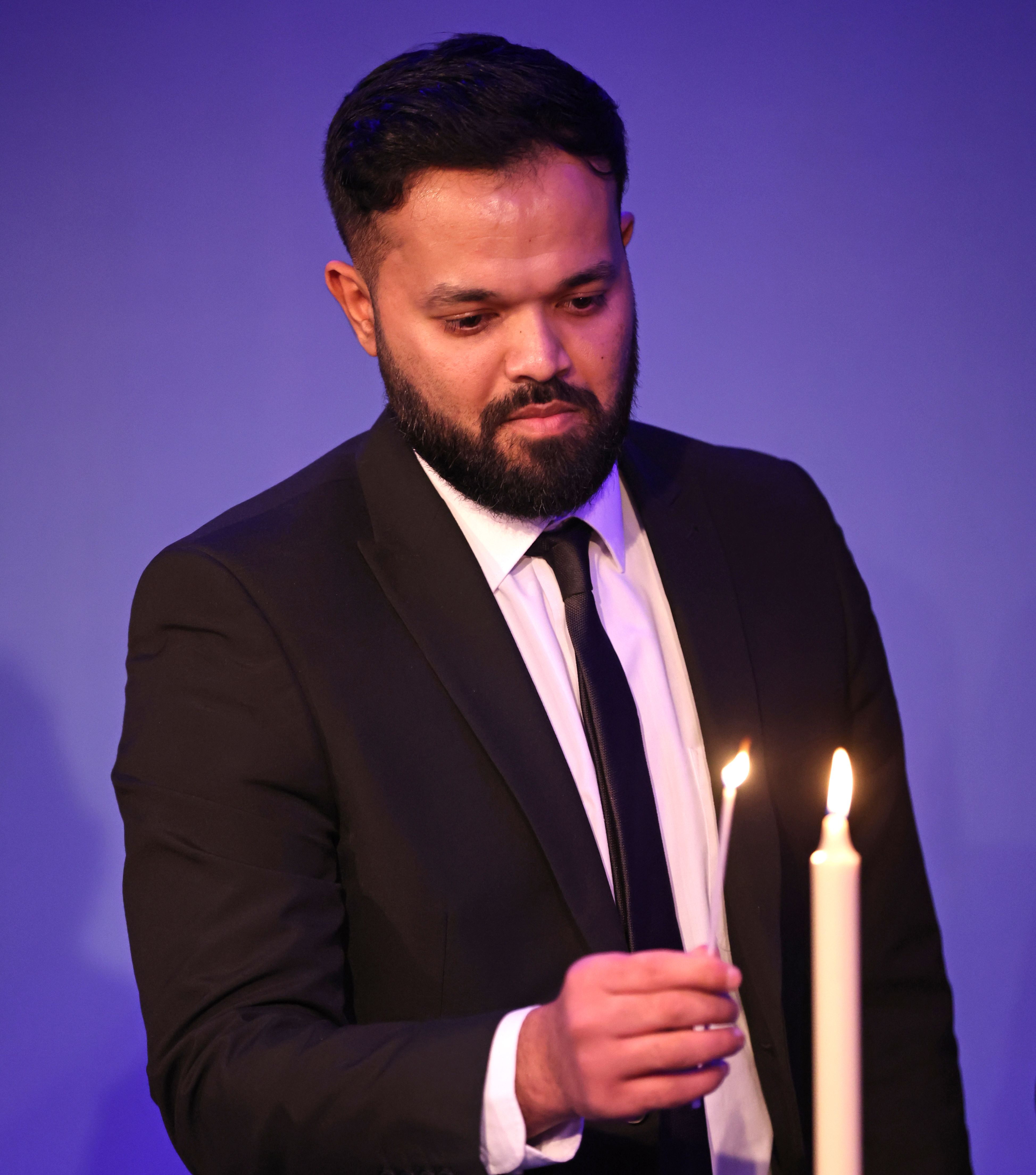 Azeem Rafiq takes part in a candle lighting ceremony during a reception for the Anne Frank Trust at the InterContinental London.