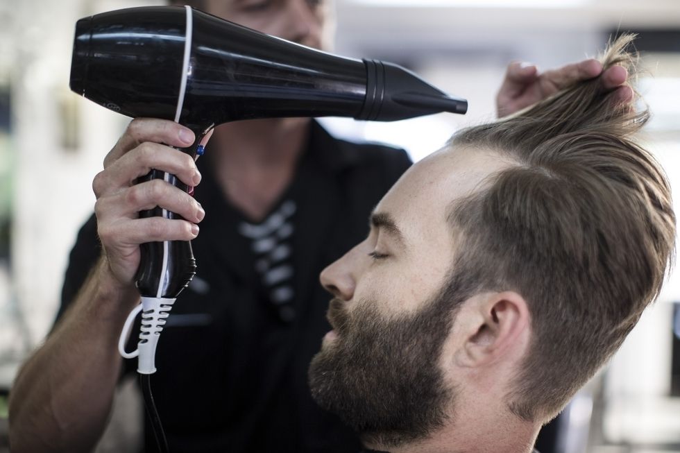 Barber blow-drying a man's hair