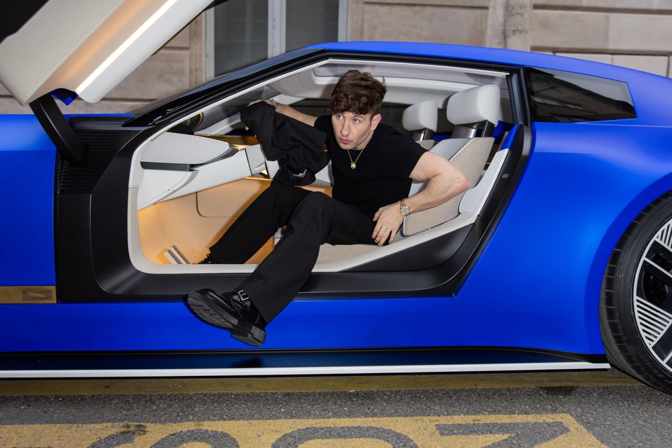 Barry Keoghan stepping out of the Jaguar Type 00 at Paris Fashion Week