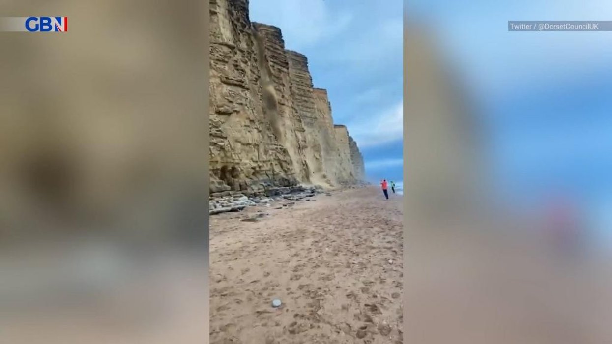 Watch moment trio run for their lives as crumbling cliff smashes onto UK beach