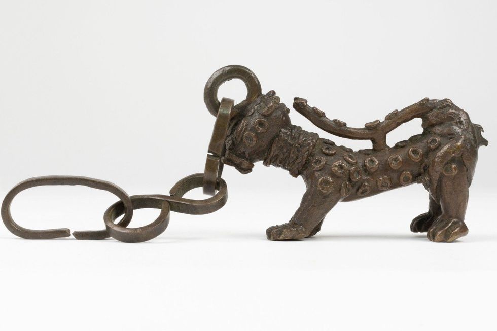 Benin Bronzes: Brass leopard with raised spots, attached by the head to a chain
