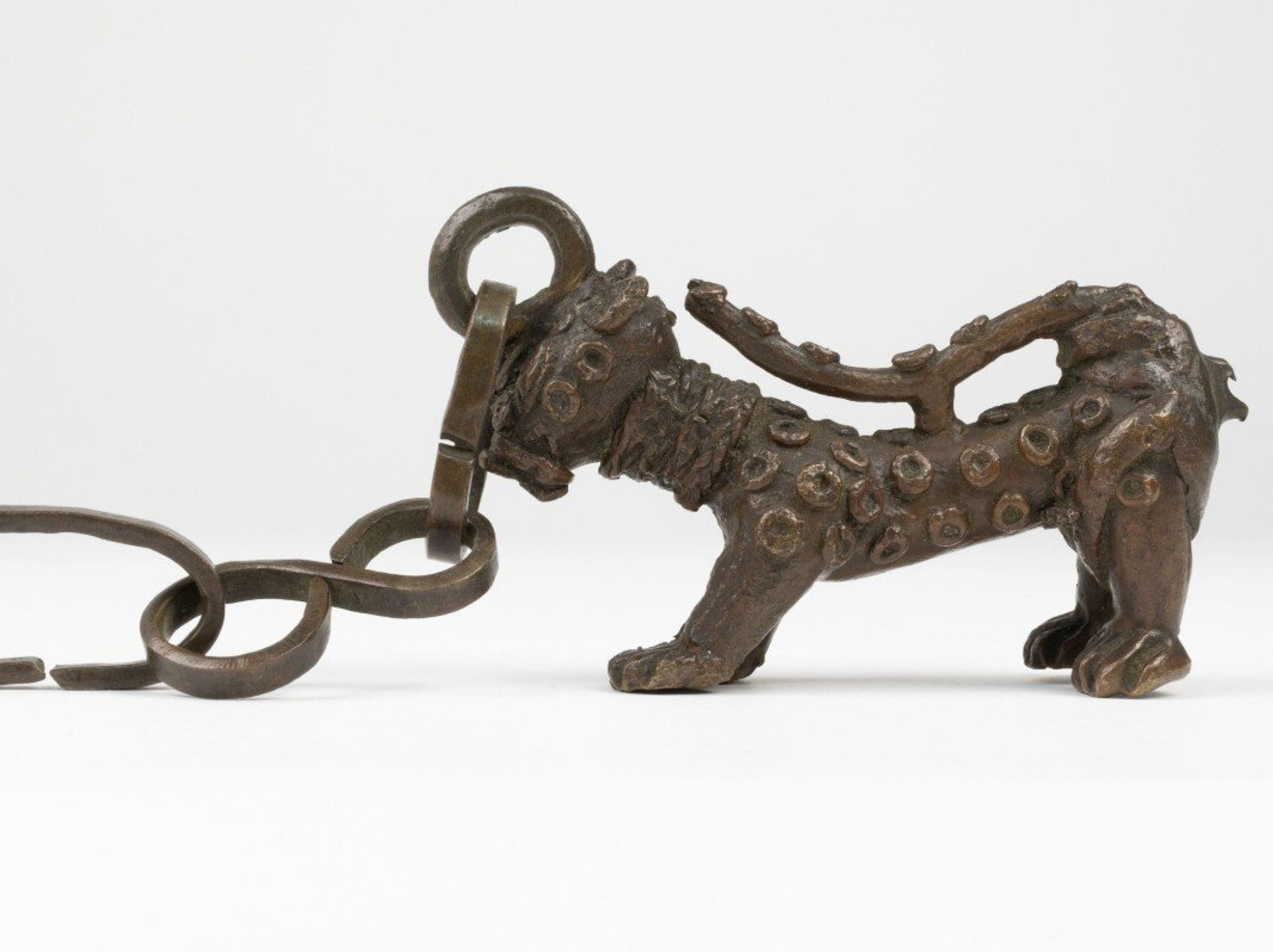 Benin Bronzes: Brass leopard with raised spots, attached by the head to a chain