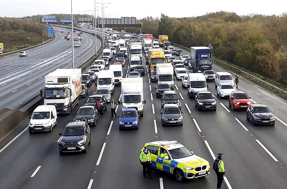 BEST QUALITY AVAILABLE Handout photo issued by Just Stop Oil of police closing the M25, where a demonstrator, from Just Stop Oil, has climbed the gantry. Issue date: Tuesday November 8, 2022.