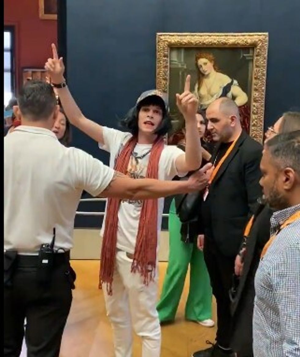 BEST QUALITY AVAILABLE Video grab dated 29/05/22 courtesy of Lukeee @lukeXC2002 of a staff members at the Louvre in Paris ushering a man away after he threw cake at Leonardo da Vinci's Mona Lisa painting whilst disguised as an elderly woman in a wheelchair. Issue date: Monday May 30, 2022.