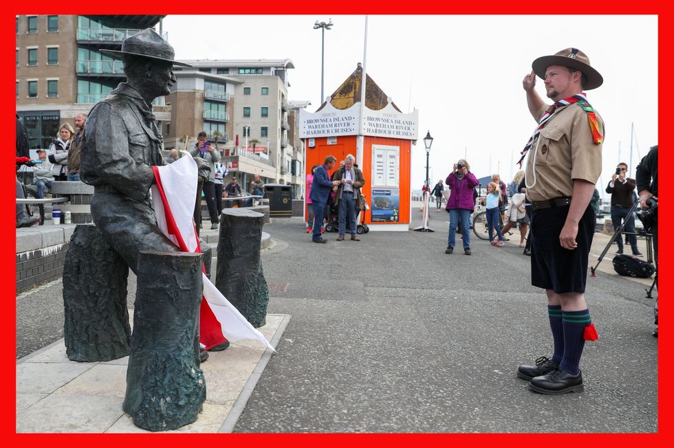 Best Rover Scout Matthew Trott salutes a statue of Robert Baden-Powell on Poole Quay in Dorset