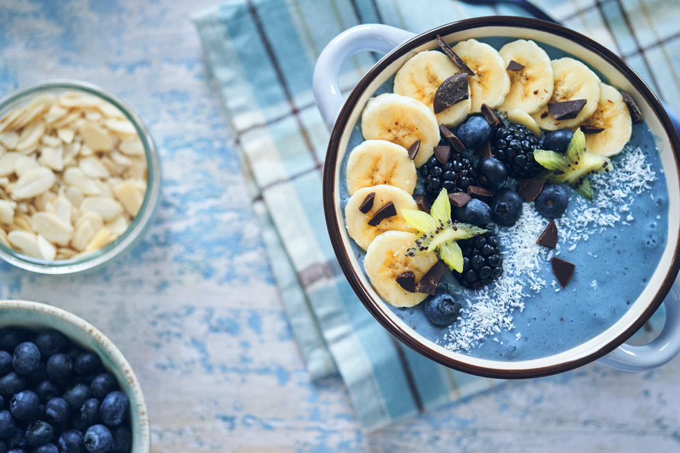 Blue smoothie bowl made with spirulina, banana, kiwis and blueberries
