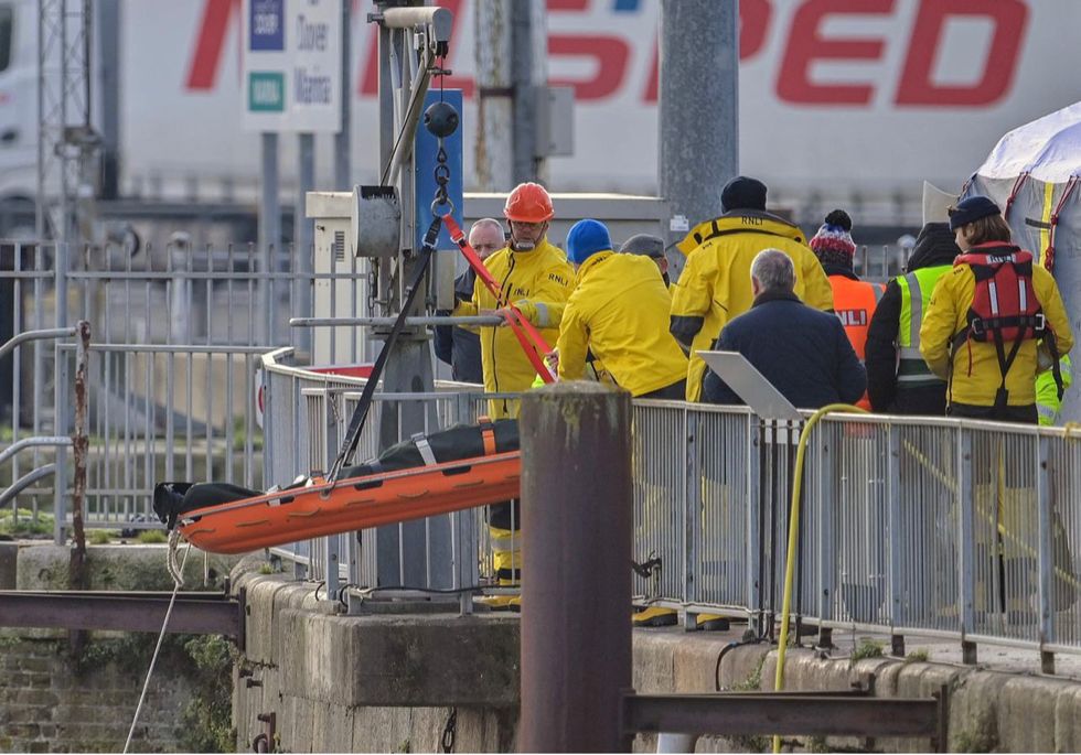 Bodies of the dead are hauled ashore after the tragedy in the English Channel
