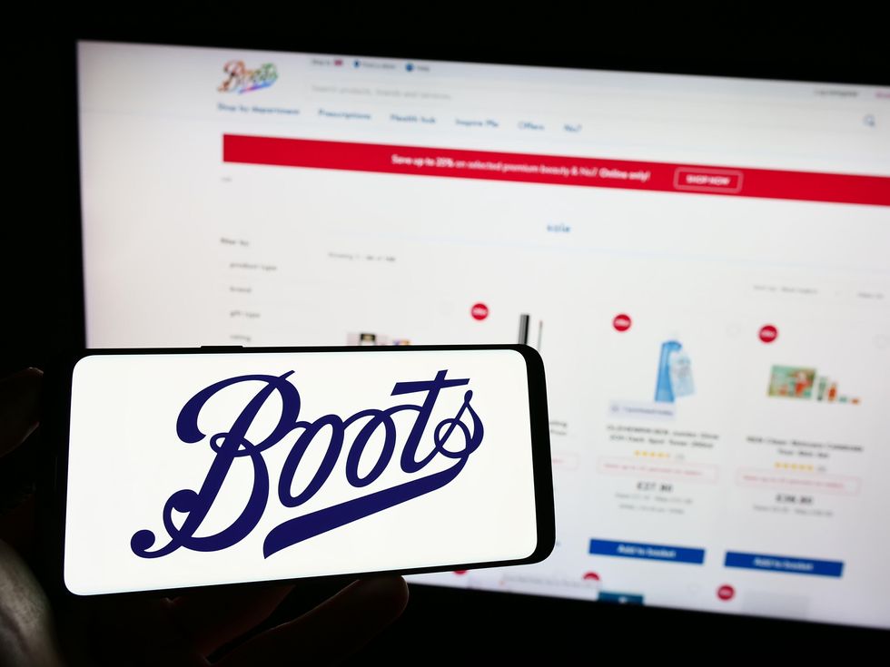 Boots logo on mobile phone in front of website