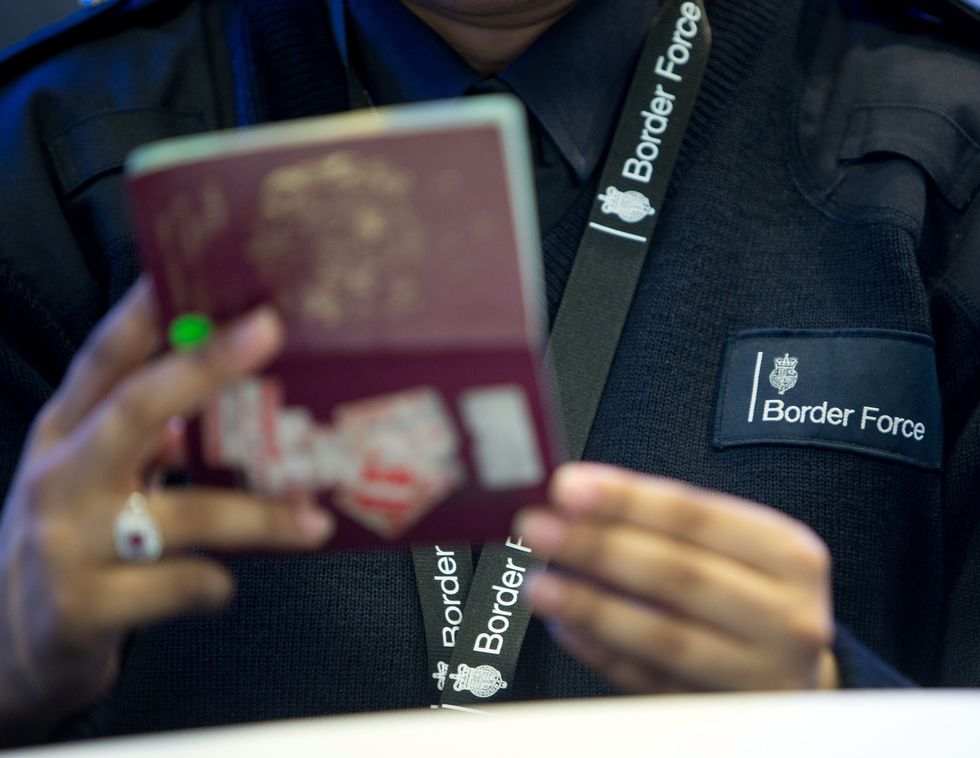 Border Force officer checking a passport