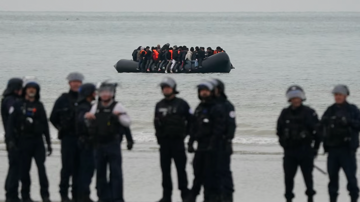 Border police patrol beach as migrant boat approaches