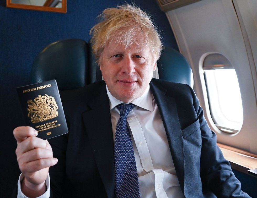 Boris Johnson holding up a new blue passport