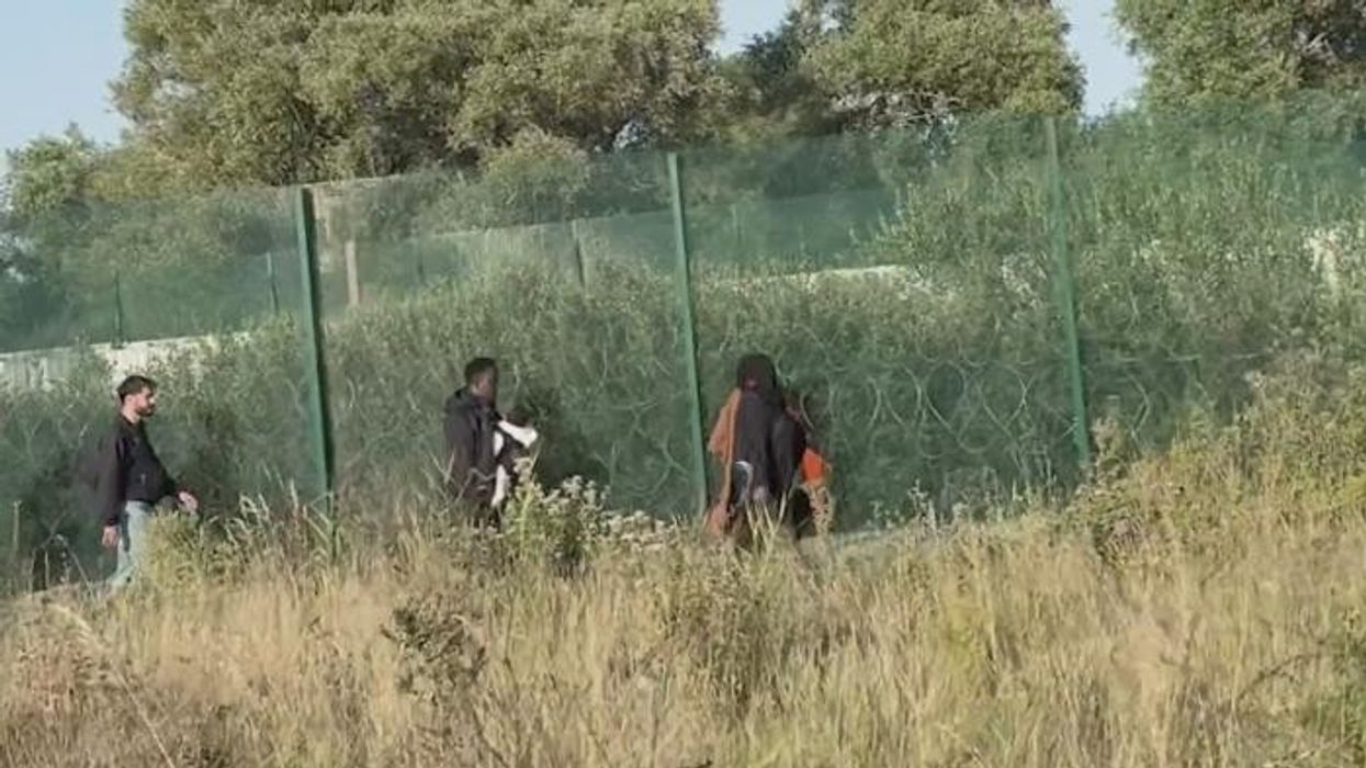'Britain is being scammed!' Robert Jenrick films migrants marching straight for the Channel as French police IGNORE his call