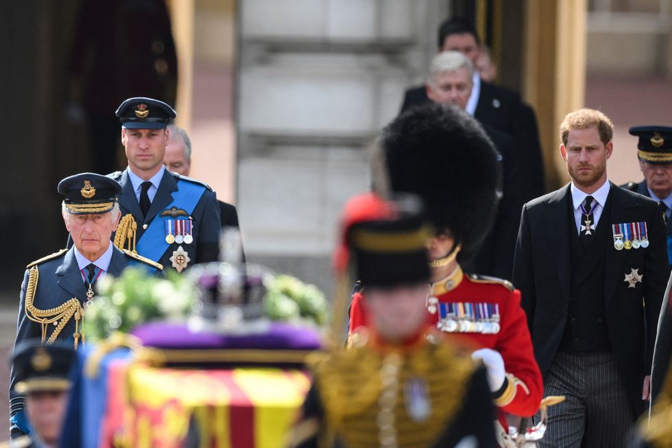 Britain's King Charles III (L), Britain's Prince William, Prince of Wales (2L) and Britain's Prince Harry, Duke of Sussex walk behind the coffin of Queen Elizabeth II, adorned with a Royal Standard and the Imperial State Crown and pulled by a Gun Carriage of The King's Troop Royal Horse Artillery, during a procession from Buckingham Palace to the Palace of Westminster, in London on September 14, 2022. DANIEL LEAL/Pool via REUTERS