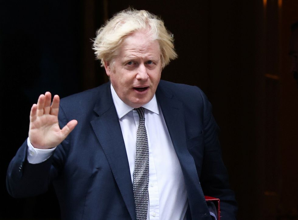 Britain's Prime Minister Boris Johnson waves as he walks on Downing Street in London