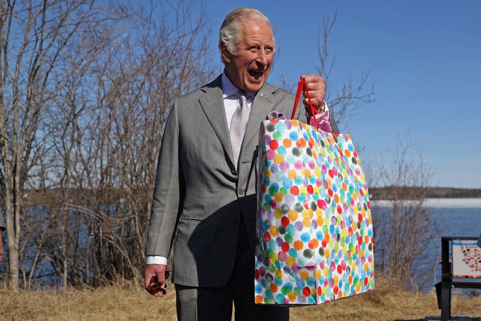 Britain's Prince Charles holds a bag as he reacts near the Great Slave Lake on the final day of his Canadian 2022 Royal Tour in Yellowknife, Northwest Territories, Canada May 19, 2022. REUTERS/Carlos Osorio TPX IMAGES OF THE DAY