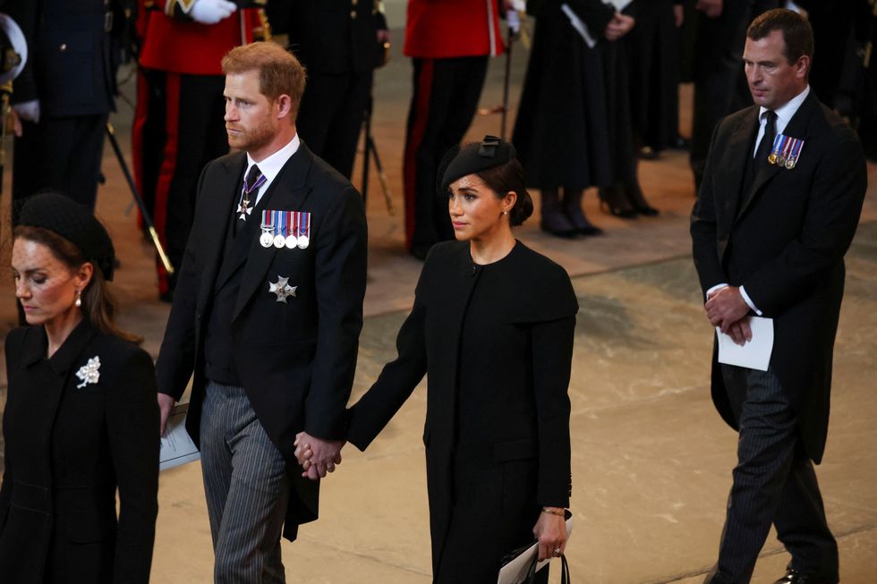 Britain's Prince Harry and Meghan, Duchess of Sussex walk as procession with the coffin of Britain's Queen Elizabeth arrives at Westminster Hall from Buckingham Palace for her lying in state, in London, Britain, September 14, 2022. REUTERS/Phil Noble/Pool