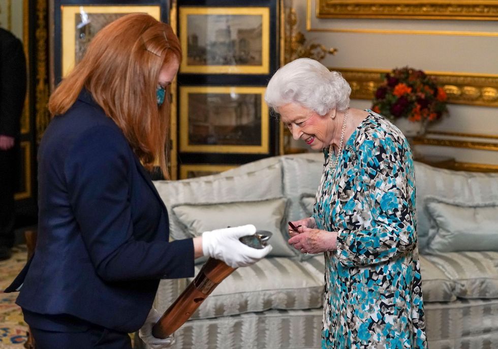 Britain's Queen Elizabeth reacts as she looks at the Birmingham 2022 Commonwealth Games Baton that will carry a message from her during a relay which starts at Buckingham Palace in London, at Windsor Castle in Windsor, Britain October 4, 2021. Picture taken October 4, 2021. Steve Parsons/Pool via REUTERS