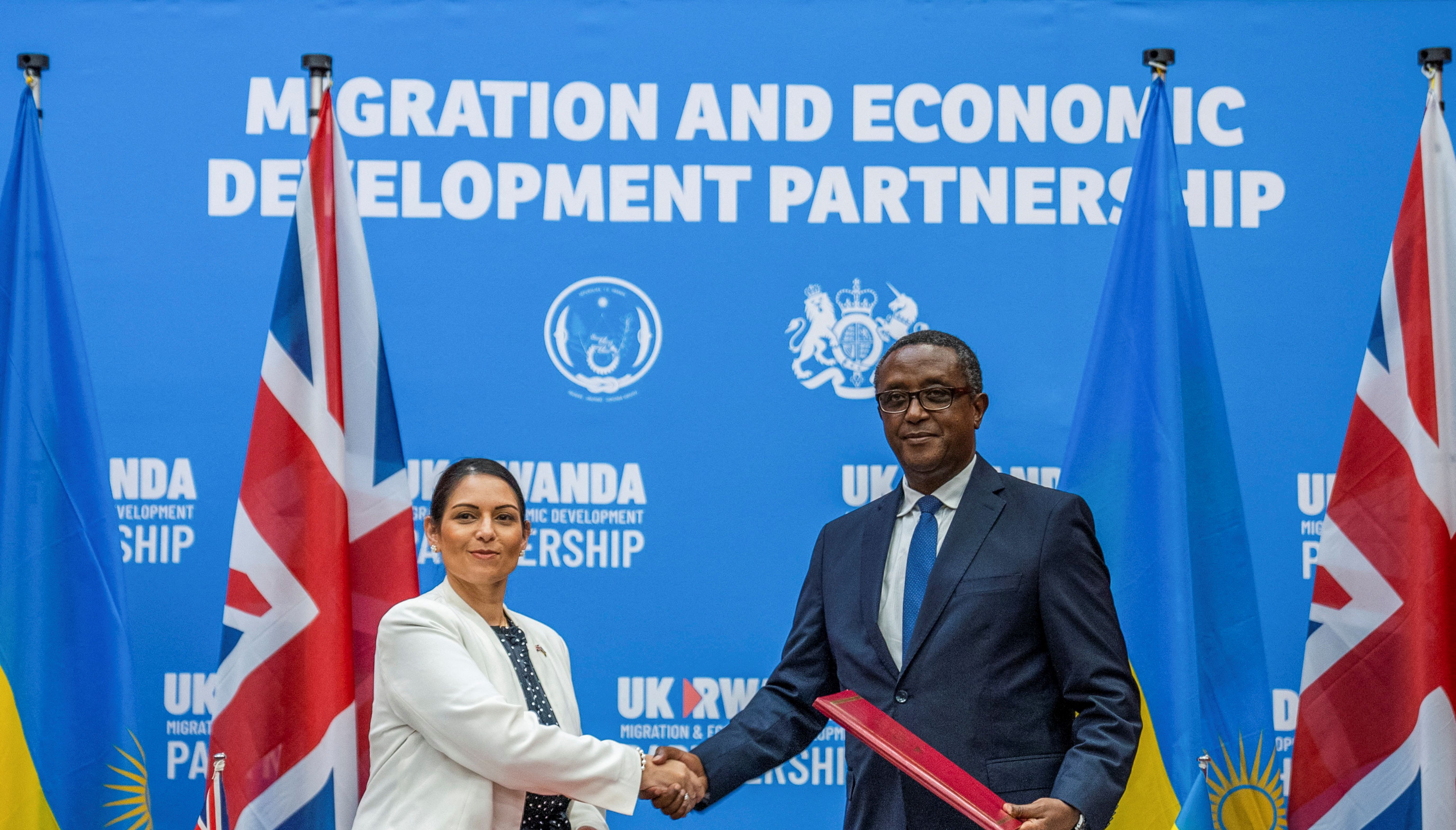British Home Secretary Priti Patel shakes hands with Rwandan Foreign Minister Vincent Birutaare