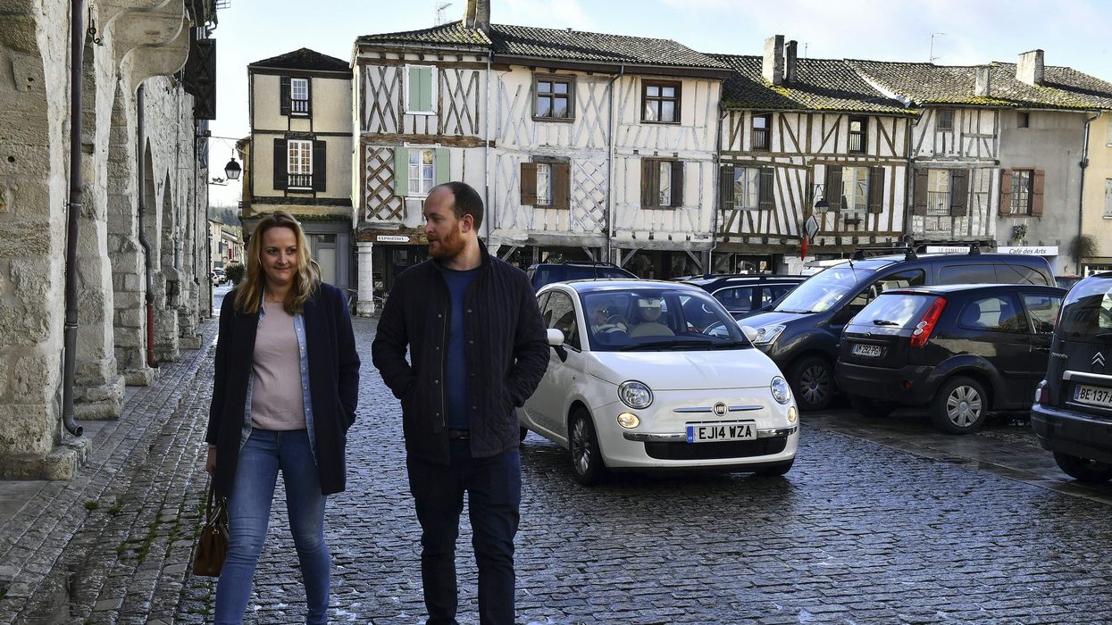 British residents Maura McGuirk (L) and James McConnel, who recently moved in Eymet, southwestern France, walk on the central square