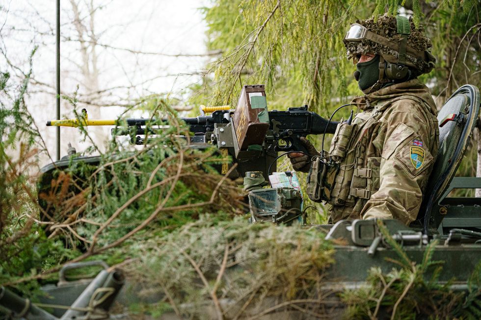British soldiers mount armoured vehicles on manoeuvres in the Tapa central military training area in Estonia on NATO exercise Bold Dragon alongside Estonian, Danish and French forces