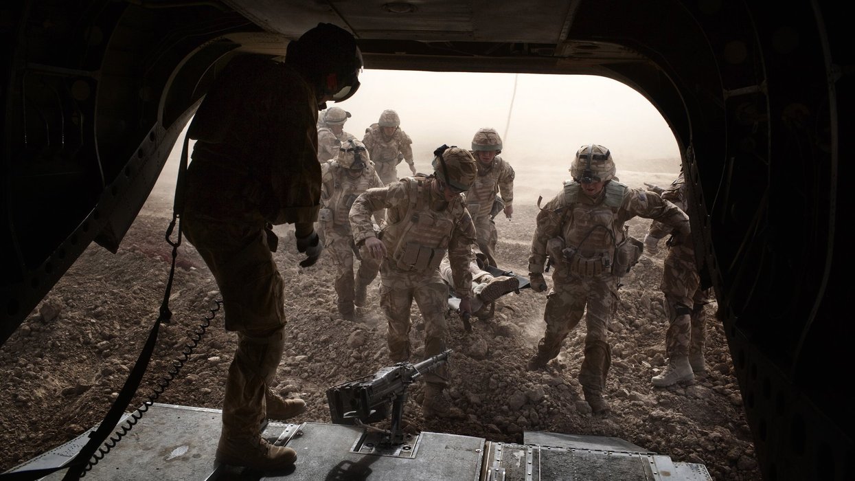 British troops carry a wounded soldier on a stretcher into a Royal Air Force Chinook