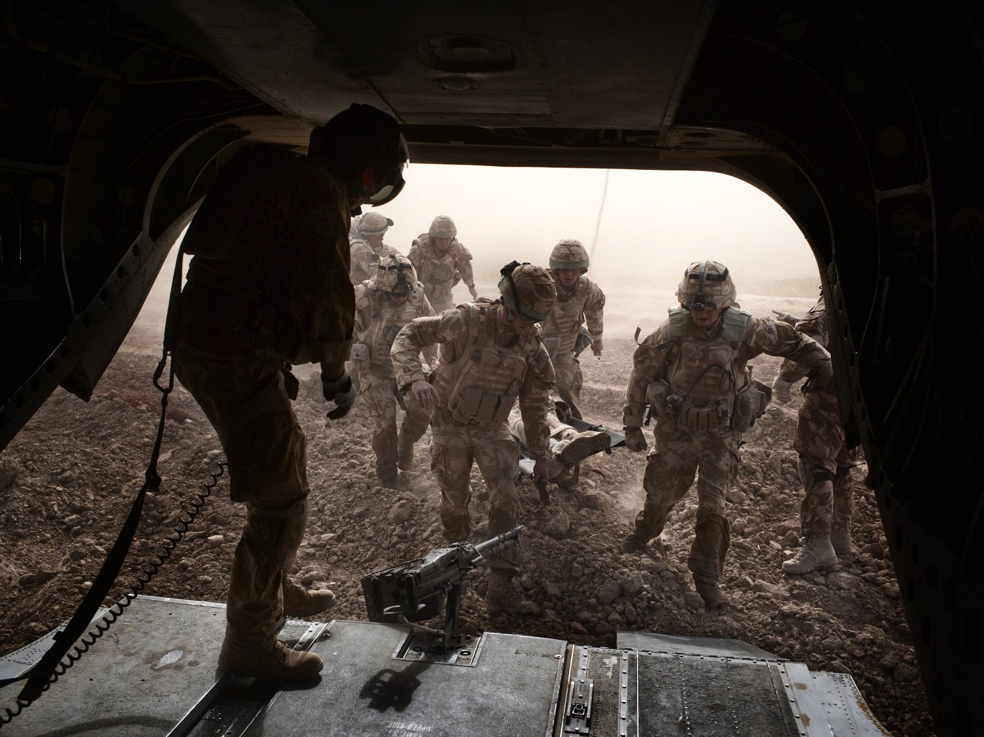 British troops carry a wounded soldier on a stretcher into a Royal Air Force Chinook