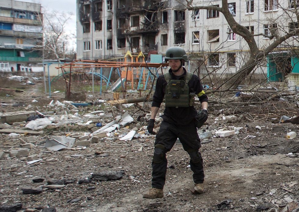 British volunteer Christopher Parry walks next to a residential building damaged by a military strike, amid Russia's attack on Ukraine, in the town of Bakhmut, Donetsk region, Ukraine January 5, 2023. REUTERS/Anna Kudriavtseva