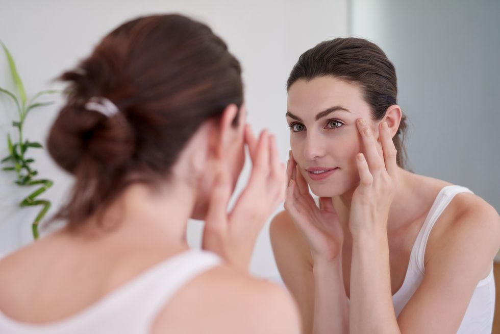 Brunette woman looking at herself in the mirror