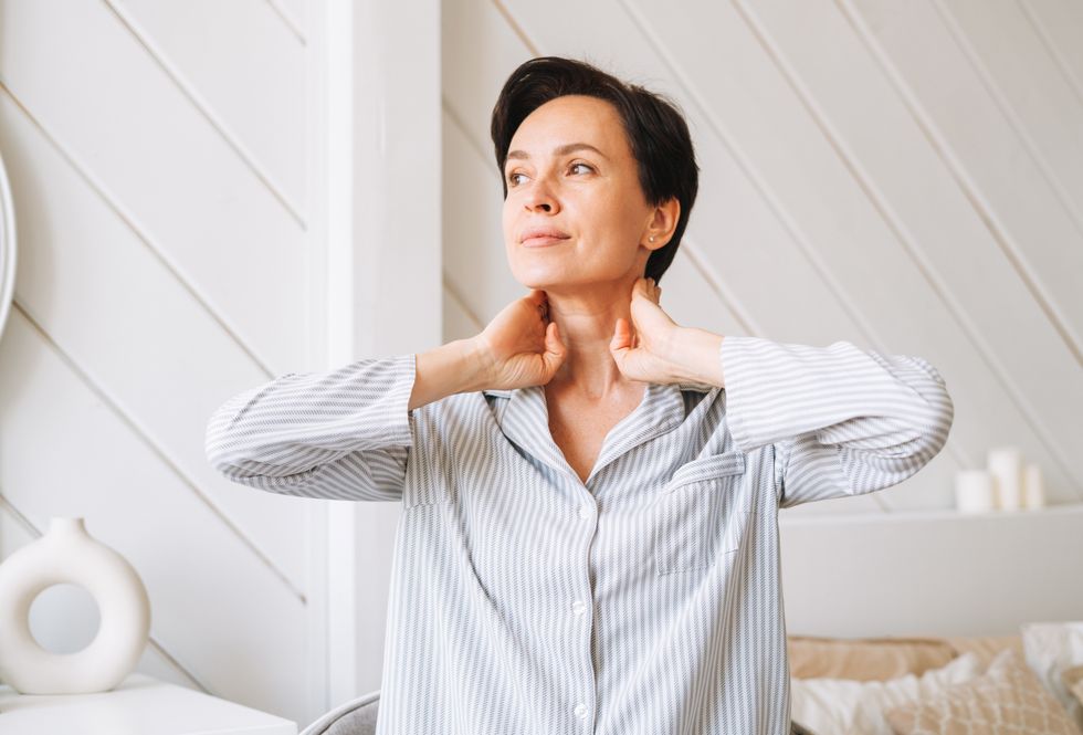 Brunette woman with clear skin wearing blue pyjamas
