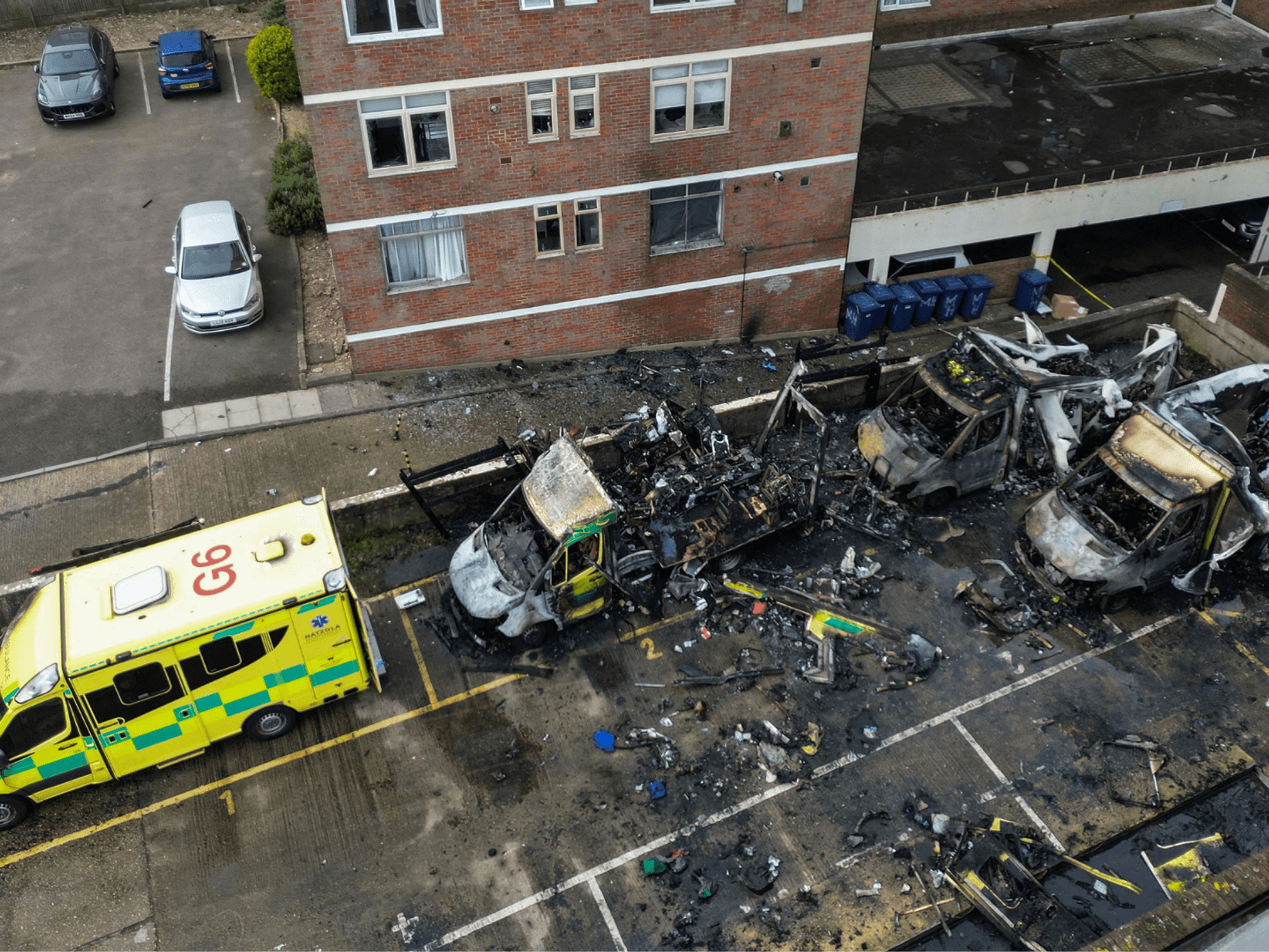 Burnt out ambulances in a parking area along a street in the Golders Green neighbourhood