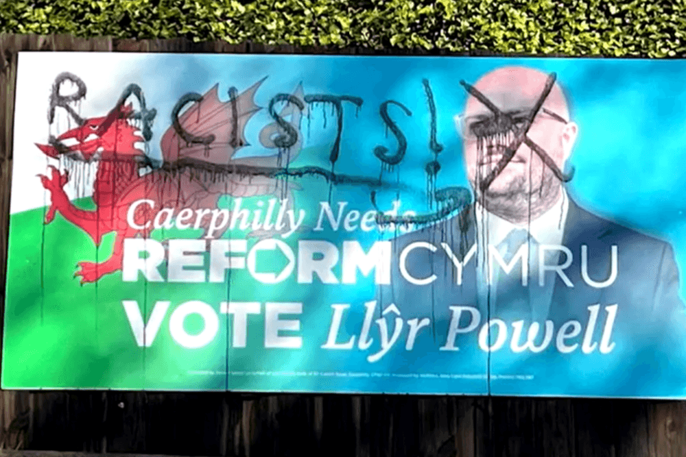 Caerphilly by-election campaign literature emblazoned with 'RACISTS' grafittied on placard