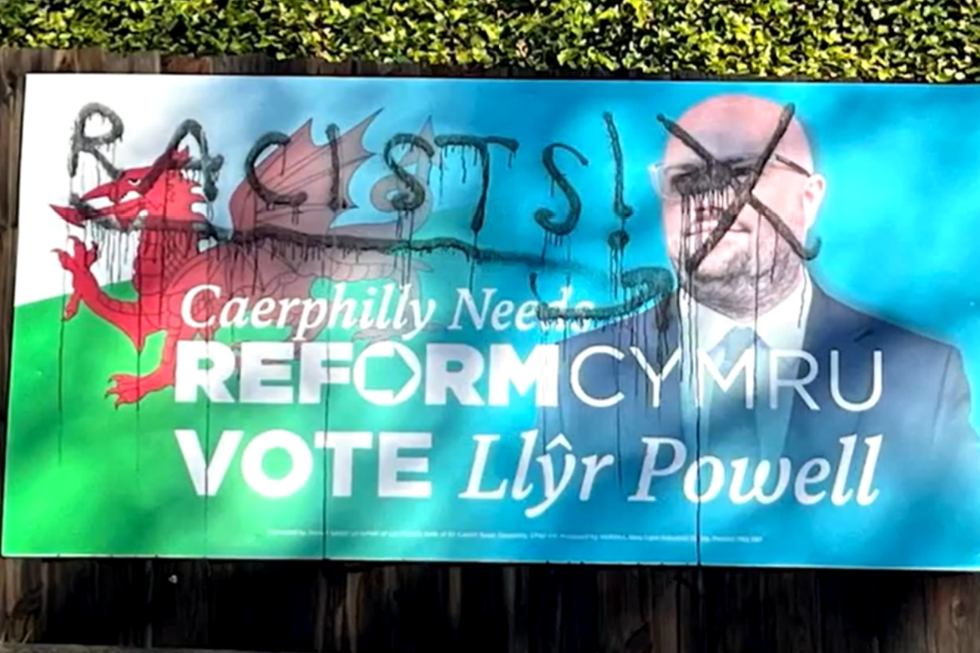 Caerphilly by-election campaign literature emblazoned with 'RACISTS' grafittied on placard