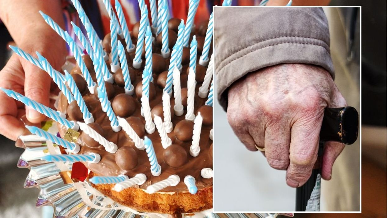 CAKE WITH CANDLES AND HAND ON WALKING STICK