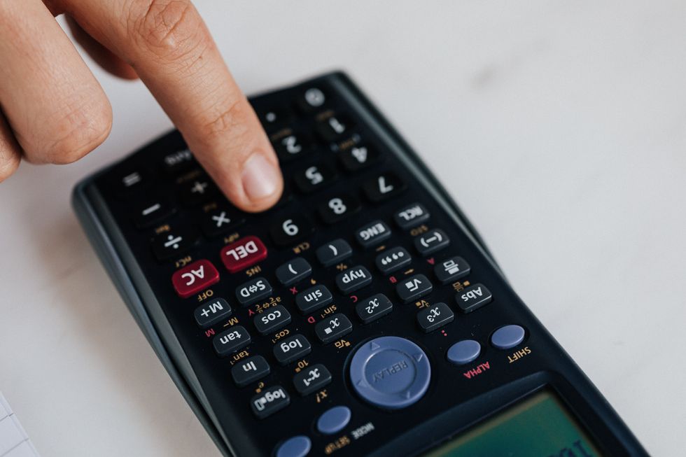 Calculator and person's finger on button