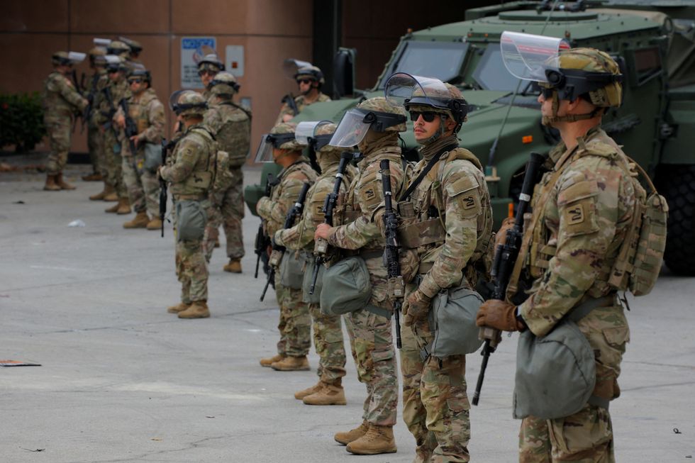California National Guard troops stand outside the Edward R. Roybal federal building, in Los Angeles