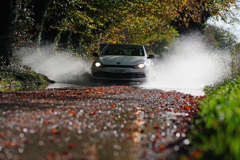 Car driving through water and leaves