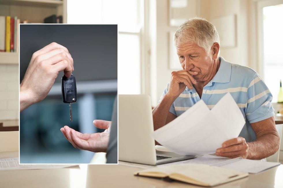 Car keys and a man checking a laptop