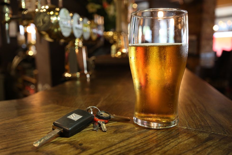 Car keys next to a pint of beer