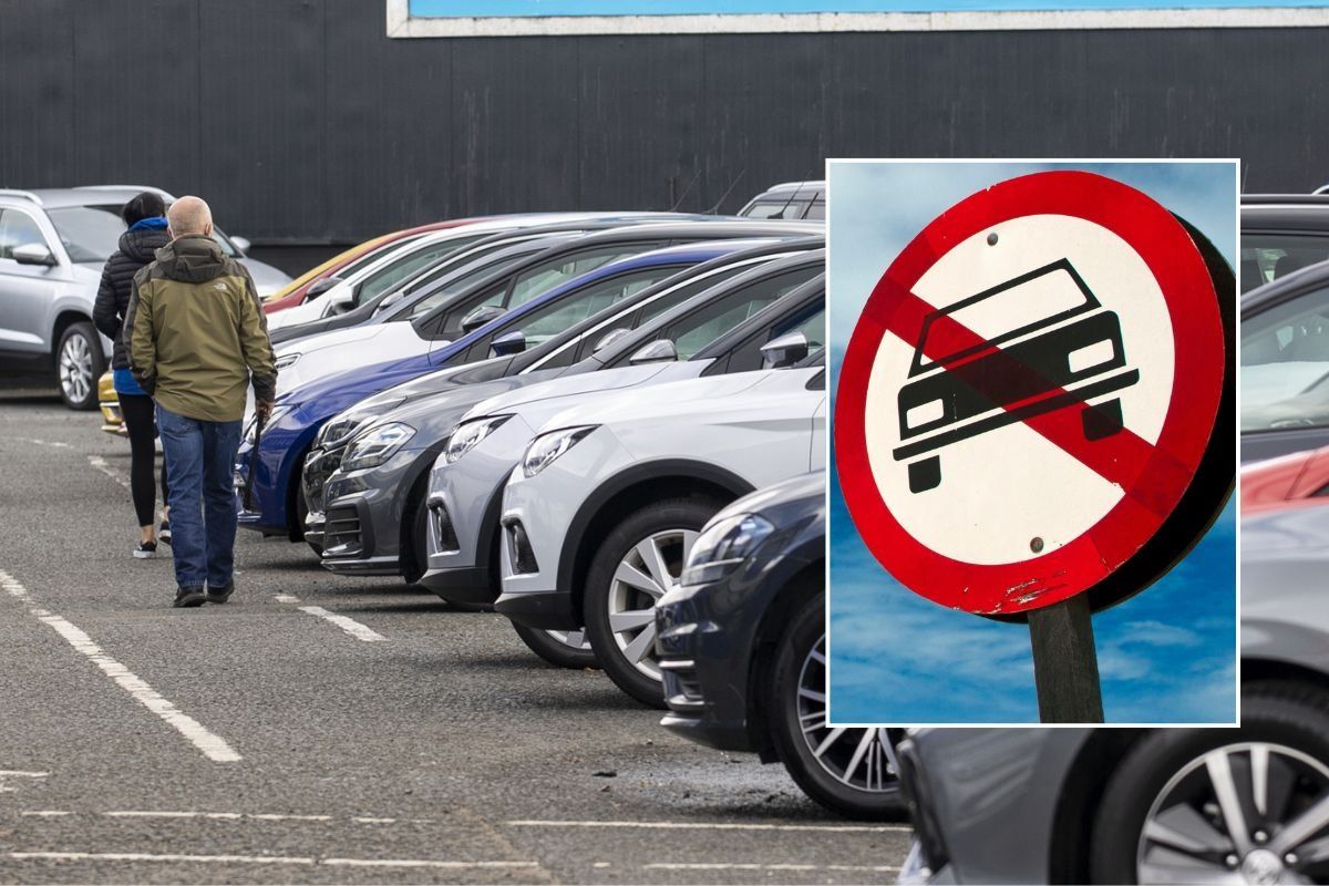 Car sales lot and a vehicle ban sign