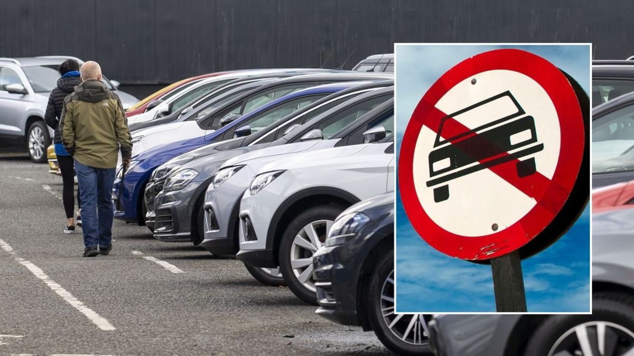Car sales lot and a vehicle ban sign