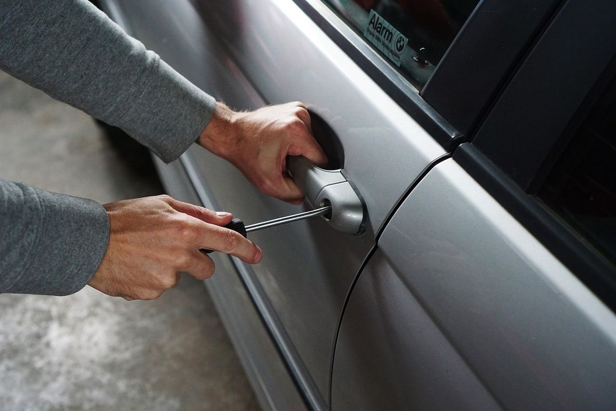 Car thief uses a screwdriver on car door