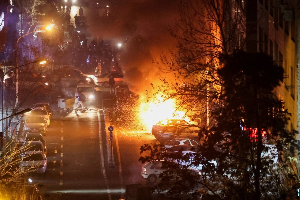 Cars burn in a street during a protest over the collapse of the currency's value, in Tehran,
