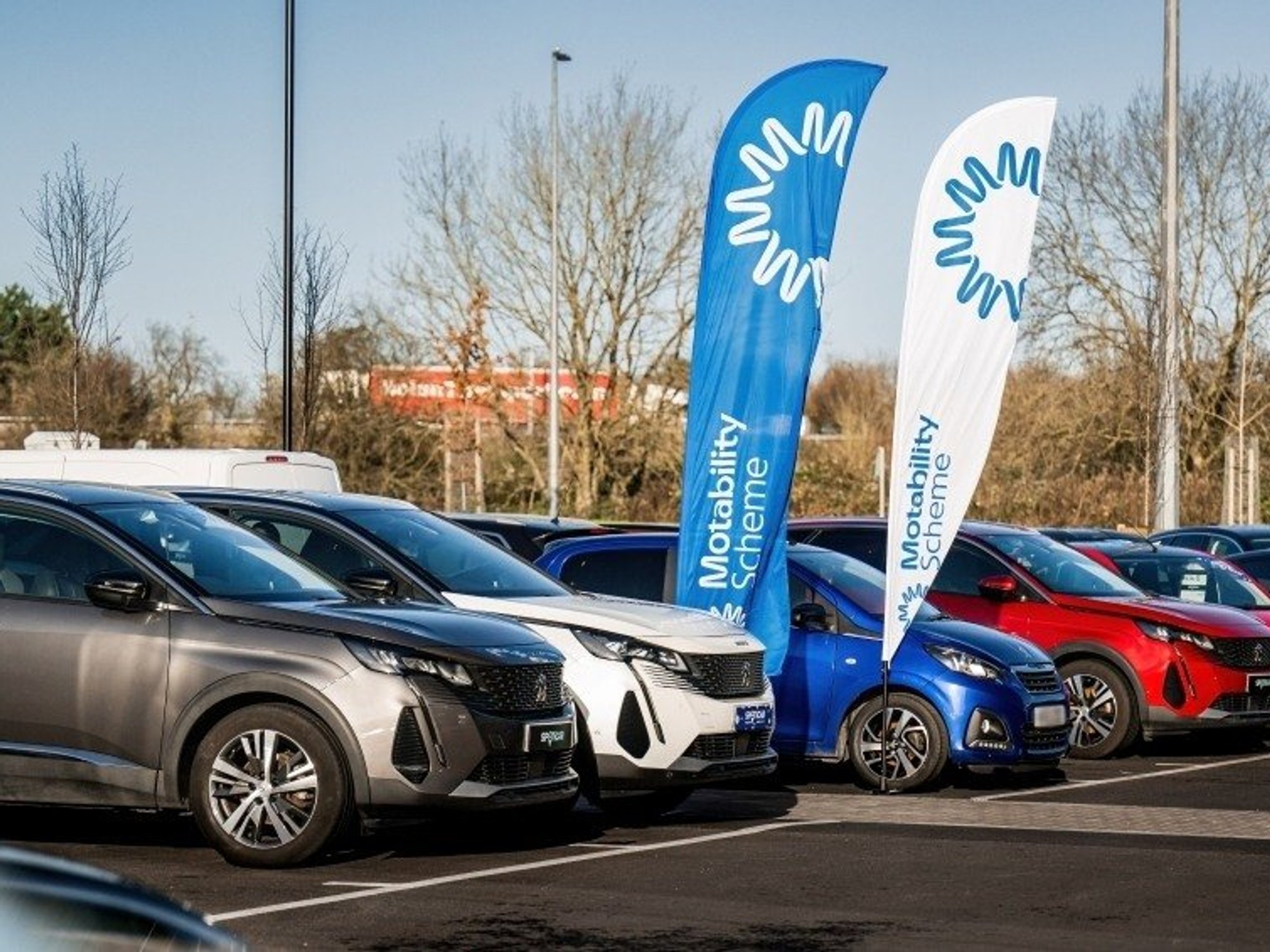 Cars parked in front of a Motability sign